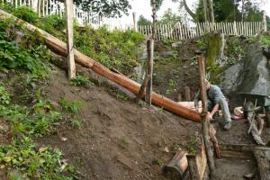 Further preparation for the second set of steps leading up to the second level of the garden Landscaper at work on natural wood steps