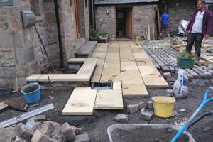 Laying paving outside the entrance to the High Casterton house Landscaping work paving using york stone kirkby lonsdale